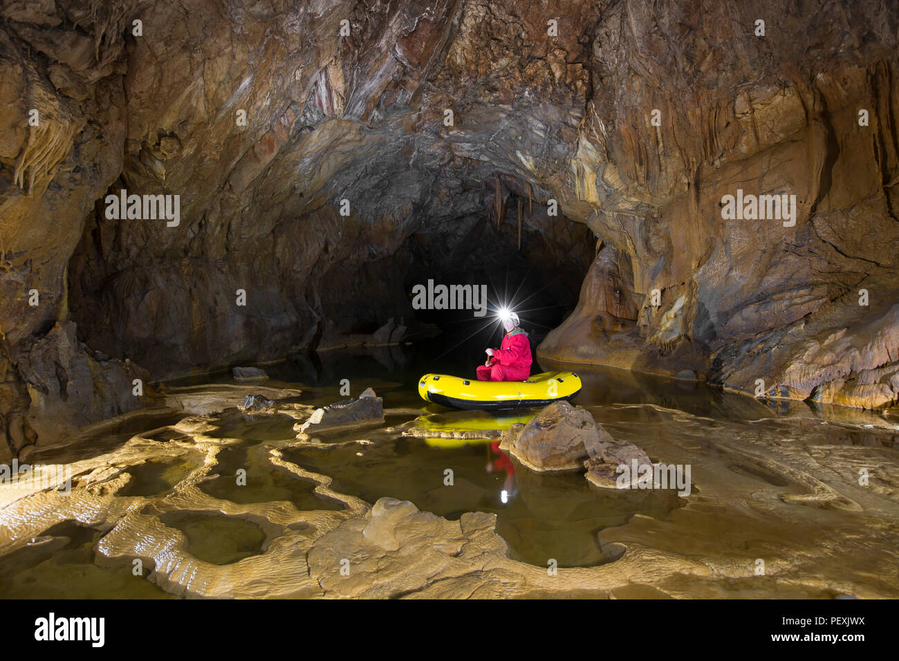 Un homme à la découverte de la grotte de Krizna Jama par bateau. Région de Karst, la Slovénie. Banque D'Images