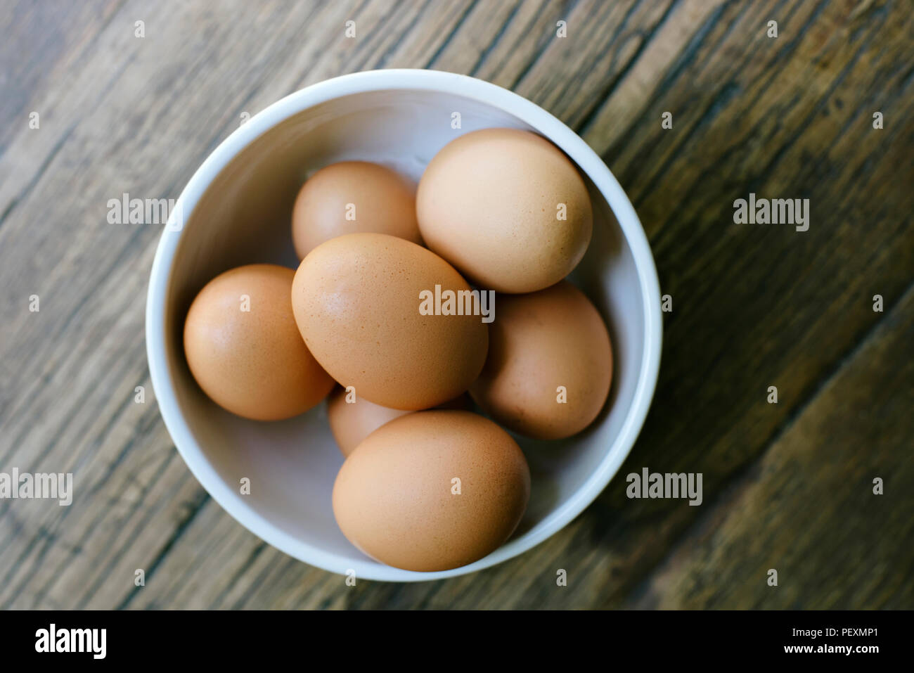 Des œufs frais dans un bol sur une table de ferme Banque D'Images