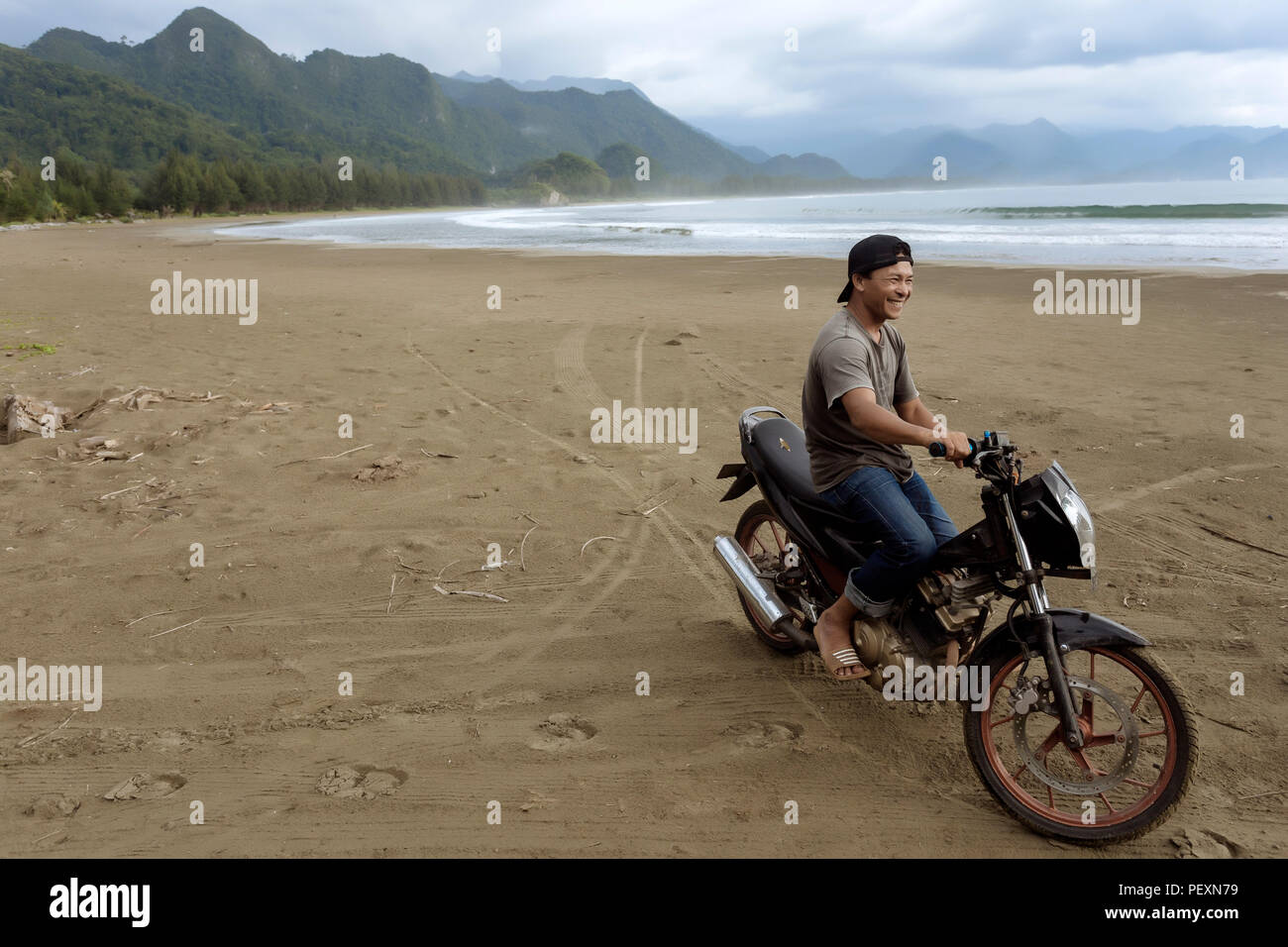 Asian man on motorcycle sur plage, Banda Aceh, Sumatra, Indonésie Banque D'Images