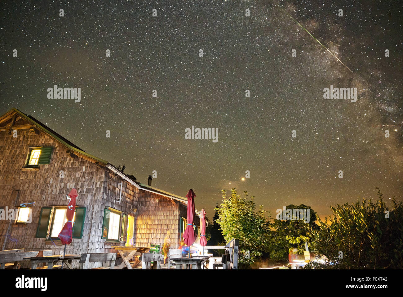Chalet de montagne en Autriche dans la nuit avec un ciel étoilé montrant  Voie lactée et les étoiles filantes des Perséides, ainsi que des planètes  Mars et Saturne Photo Stock - Alamy