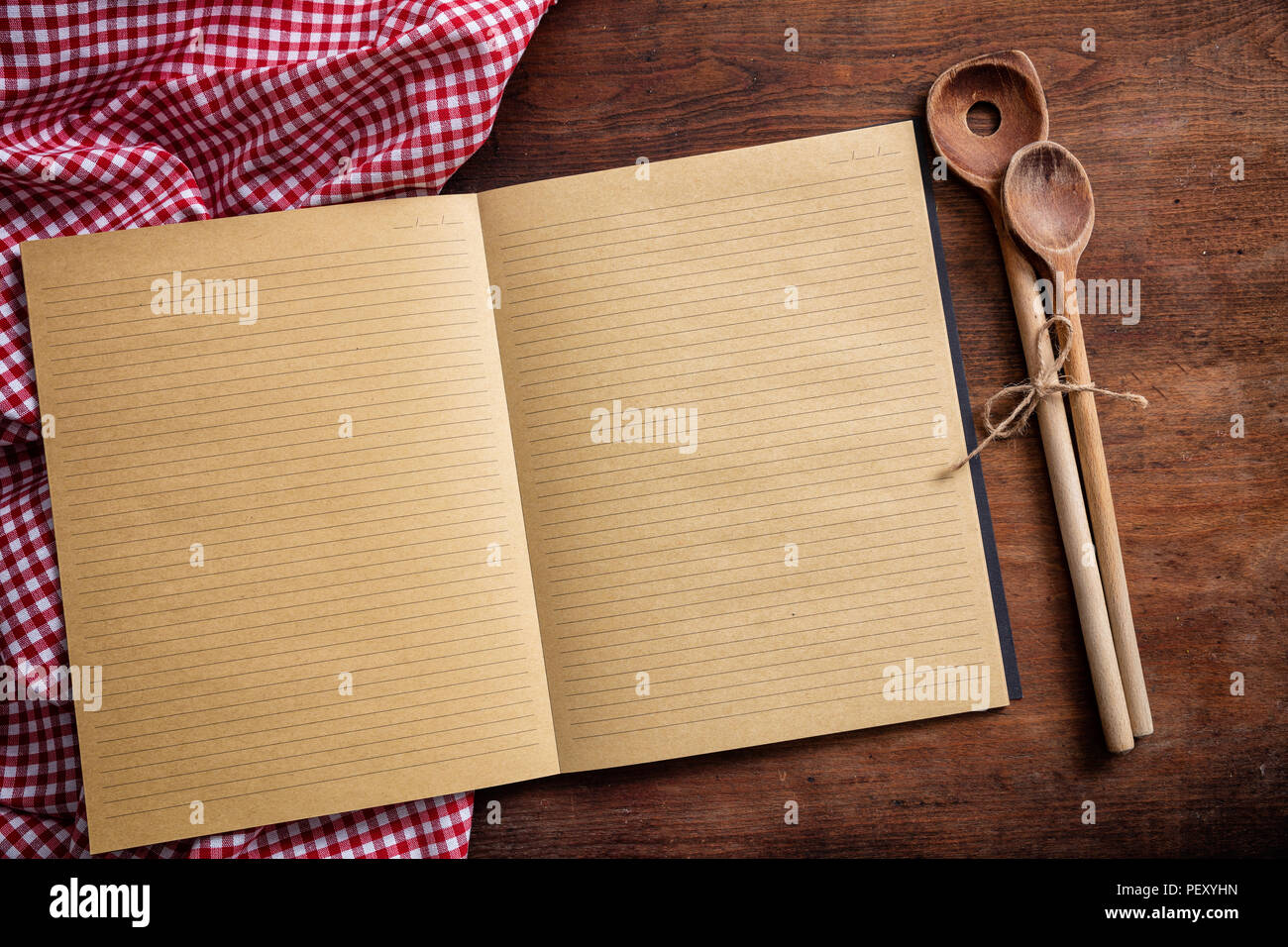 Recette de cuisine. Ordinateur portable blanc, des ustensiles de cuisine et nappe rouge sur la table en bois, vue du dessus, copy space Banque D'Images