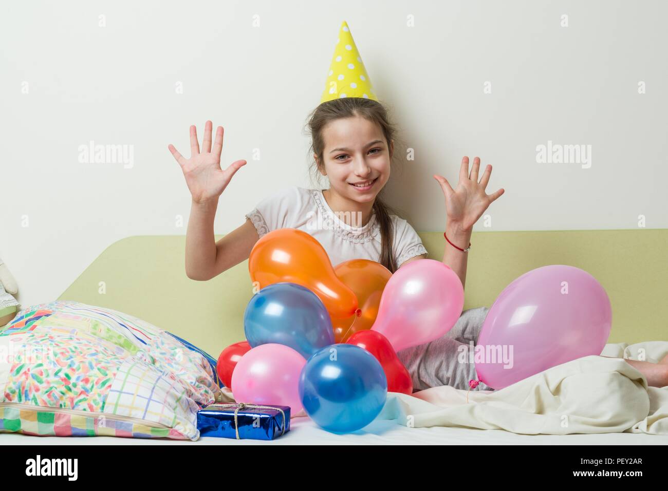 L Anniversaire D Une Adolescente Est De 10 Ans Une Fille Dans Un Chapeau De Fete Avec Un Cadeau Se Trouve Sur Le Lit Dans Une Chambre D Enfants Fille Revele Dix Signe Avec Son L Anniversaire D Une Adolescente Est De 10 Ans Une Fille Dans Un Chapeau De Fete Avec Un Cadeau Se Trouve Sur Le Lit Dans Une Chambre D Enfants Fille Revele Dix Signe Avec Son