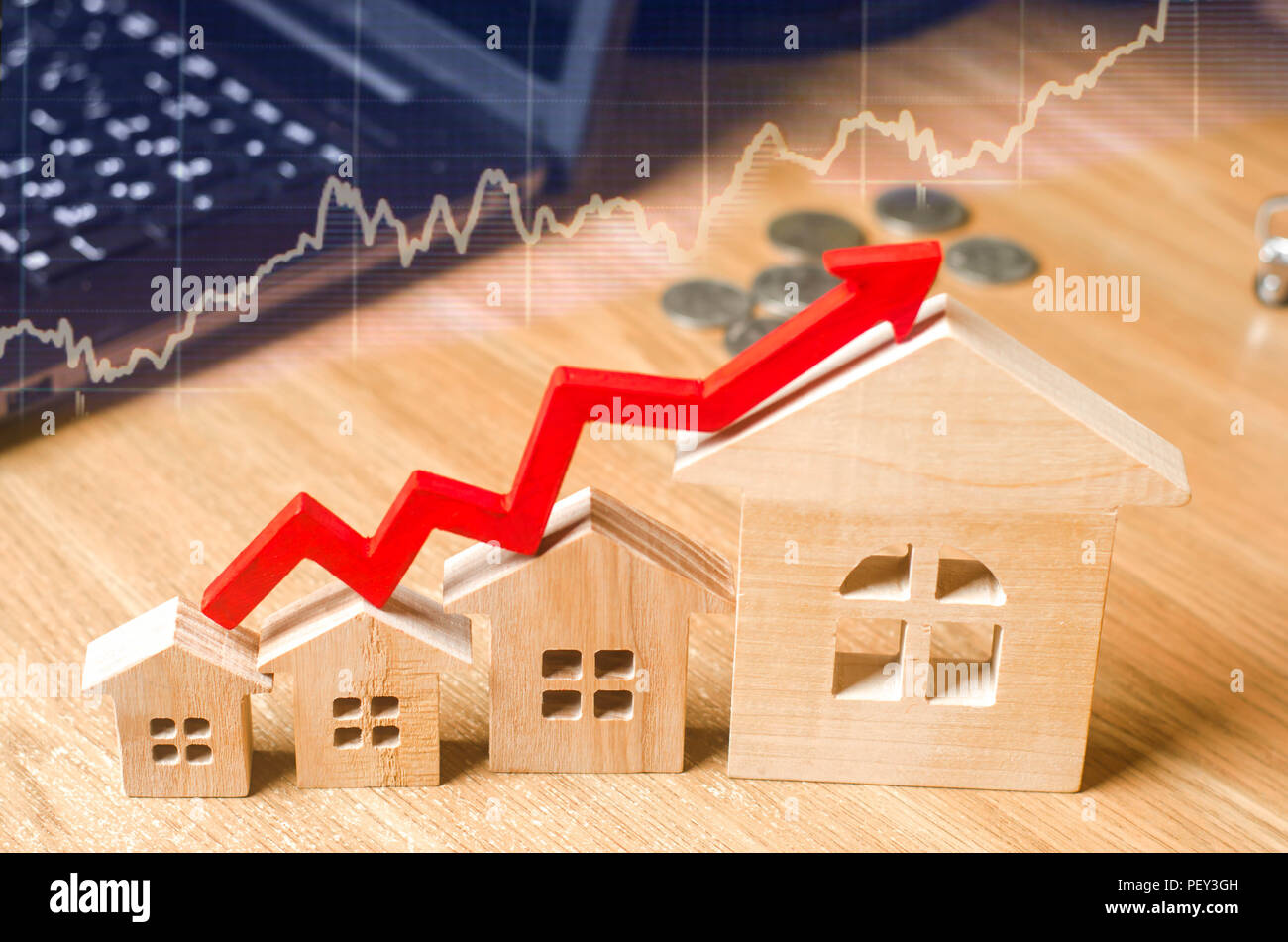 Une flèche rouge au-dessus des maisons en bois. Concept de l'augmentation de l'offre et la demande sur le marché immobilier. Augmentation du coût et des prix des maisons, b Banque D'Images