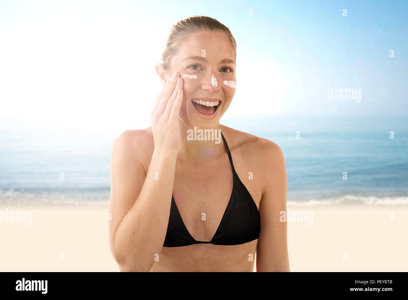 Appliquez un écran solaire Femme à son visage. Banque D'Images