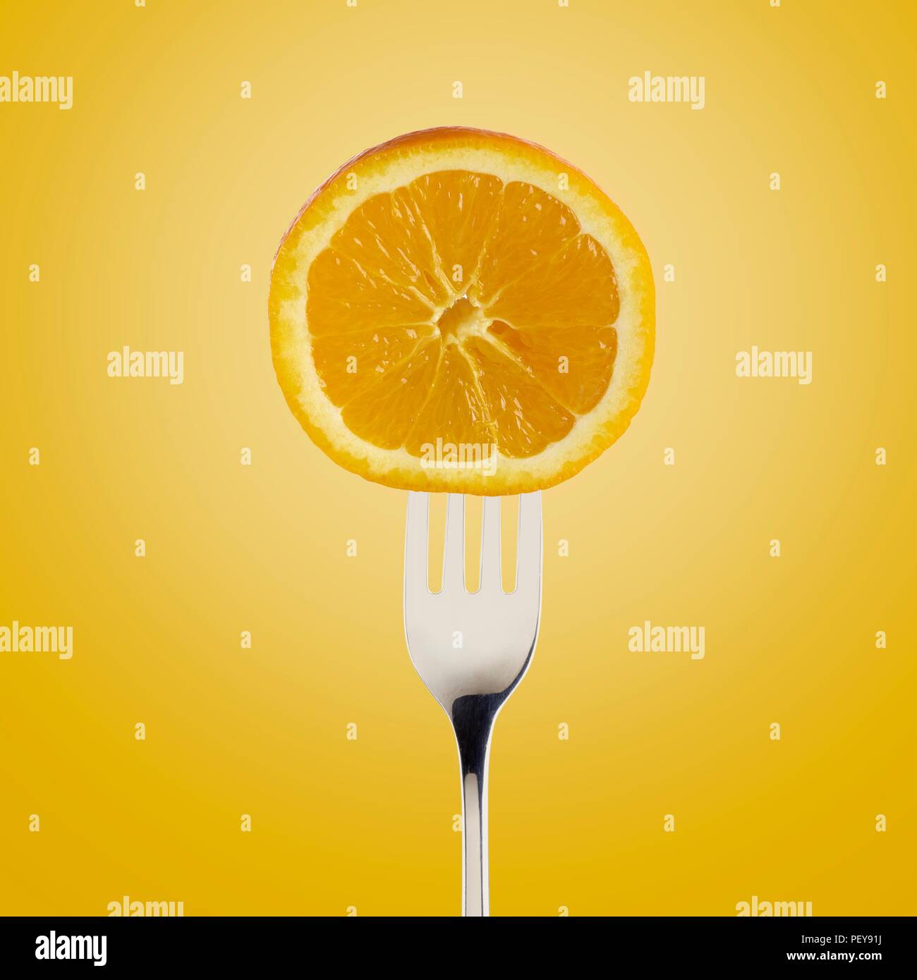 Orange réduit de moitié sur la fourchette. Banque D'Images
