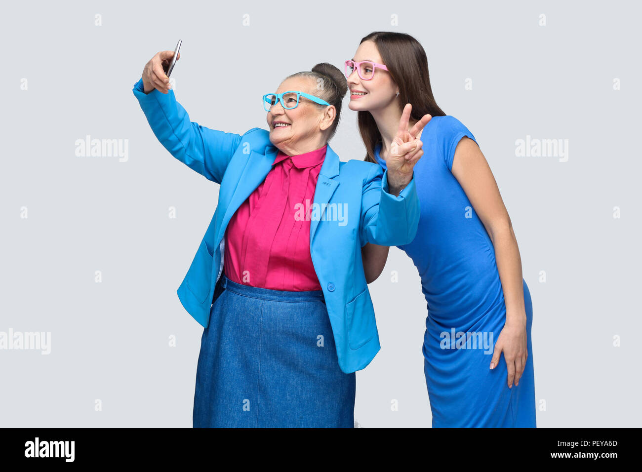 Heureux grand-mère avec sa petite-fille en robe bleue et répondre à l'article, poser et faire sourire à pleines dents et selfies. Les relations dans la famille. piscine, st Banque D'Images