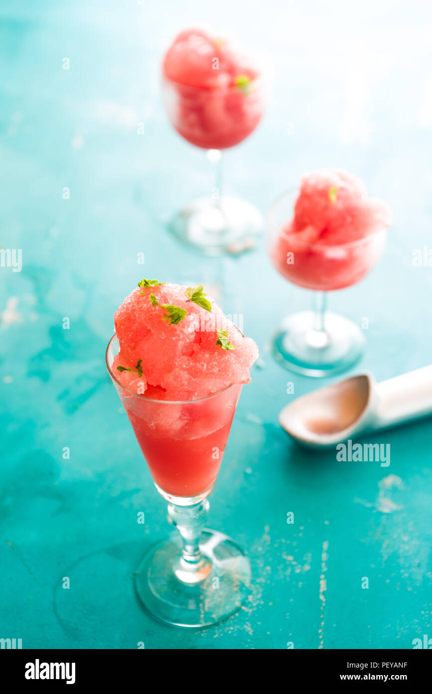Warermelon granita sur un petit verre sur un fond bleu avec l'accent technique sélective Banque D'Images