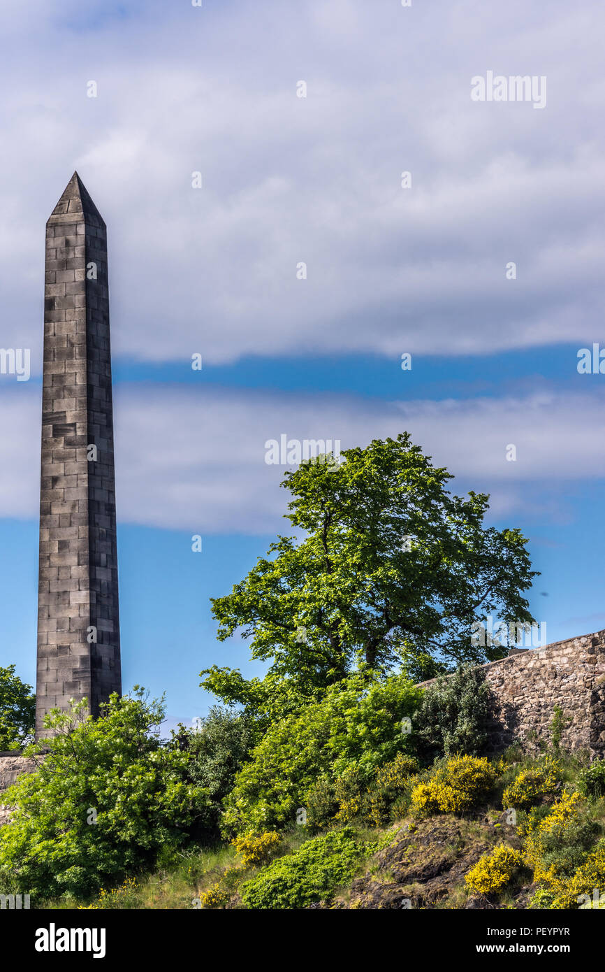 Edimbourg, Ecosse, ROYAUME UNI - 13 juin 2012 : Martyrs de Monument de la réforme, l'obélisque, à l'ancien cimetière de Calton, vu sur la falaise verte sous ciel nuageux. Banque D'Images