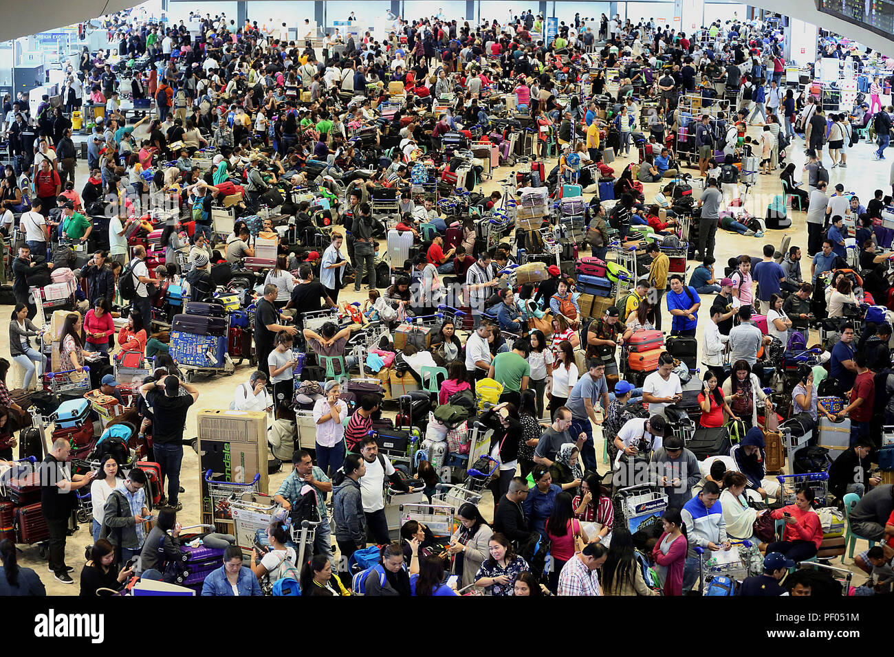 Paranaque City, Philippines. Août 18, 2018. Une foule de passagers abandonnés à attendre pour la reprise de leurs vols à l'aéroport international Ninoy Aquino (NAIA) à Paranaque city, Philippines, le 18 août 2018. Les autorités de l'aéroport des Philippines a réouvert le samedi sa principale piste de l'Aéroport International de Manille heures après l'enlèvement de la mal-avion de passagers Air Xiamen endommagé qui a glissé hors de la piste jeudi. Credit : Rouelle Umali/Xinhua/Alamy Live News Banque D'Images