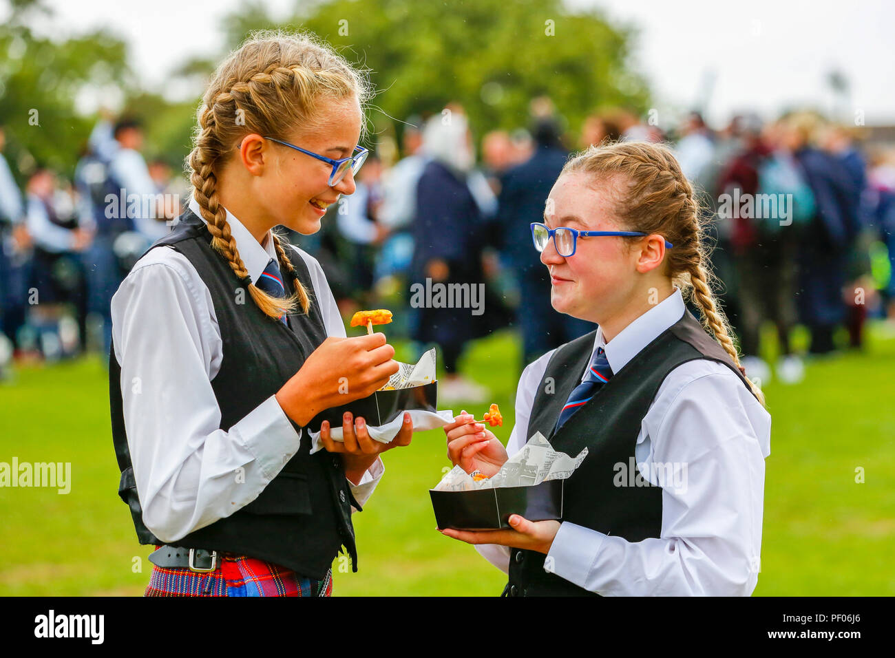 La finale de l'Organisation mondiale de la Pipe Band ont eu lieu à Glasgow Green dans le centre-ville et la compétition a attiré de nombreux et très célèbre pipe bands ainsi que des milliers de touristes et les spectateurs qui sont venus pour soutenir l'événement. En dépit de la douche de pluie à l'occasion, une fois de plus l'événement a été un succès et une grande promotion pour la musique de cornemuse. AIMEE McBURNEY et Ellie Wilson de l'Irlande du Nord, Ballyboley Pipe Band prendre une collation entre les concours. Banque D'Images