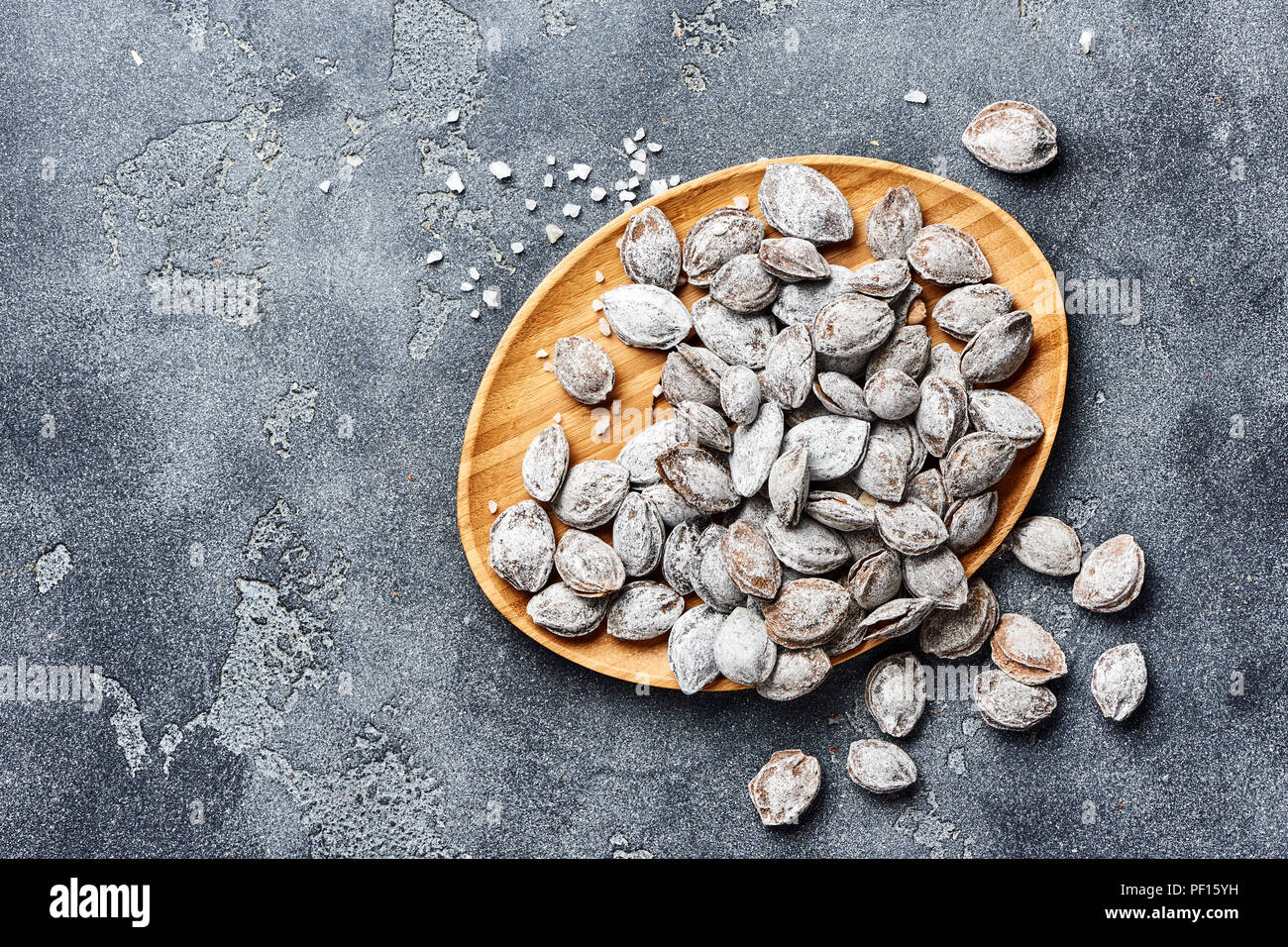 Abricots salé sur fond gris. Les os d'abricot poêlé au sel dans la cendre. Banque D'Images