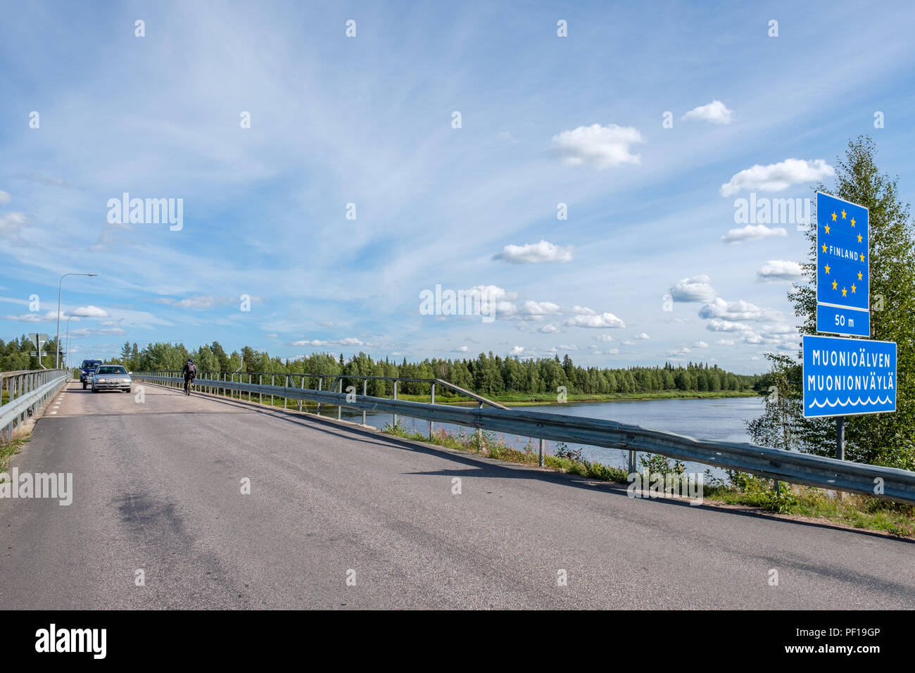 Méconnaissable biker qui franchissent la frontière de la Finlande, de la Suède à pont à Muonio River dans le nord de la Scandinavie Banque D'Images