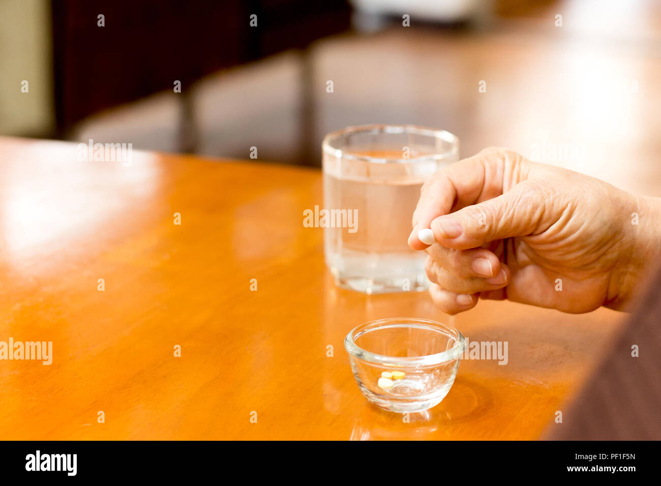 Femme âgée main tenant comp witj verre d'eau Banque D'Images