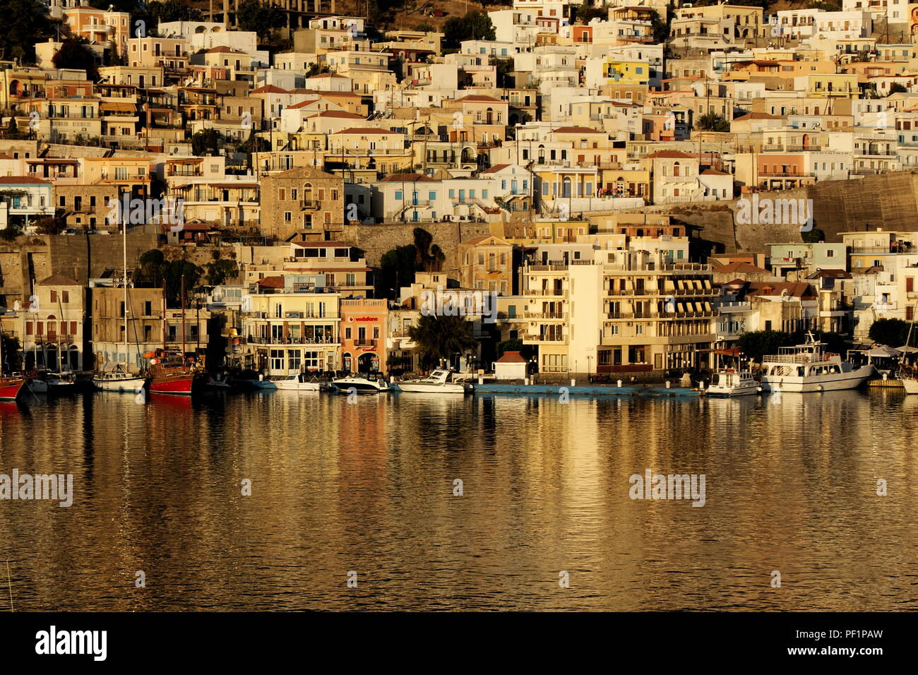 La Grèce, l'île d'Kaylmnos à l'aube. Les bâtiments néo-classique à côté du port baigné dans la lueur de l'aube du soleil Banque D'Images
