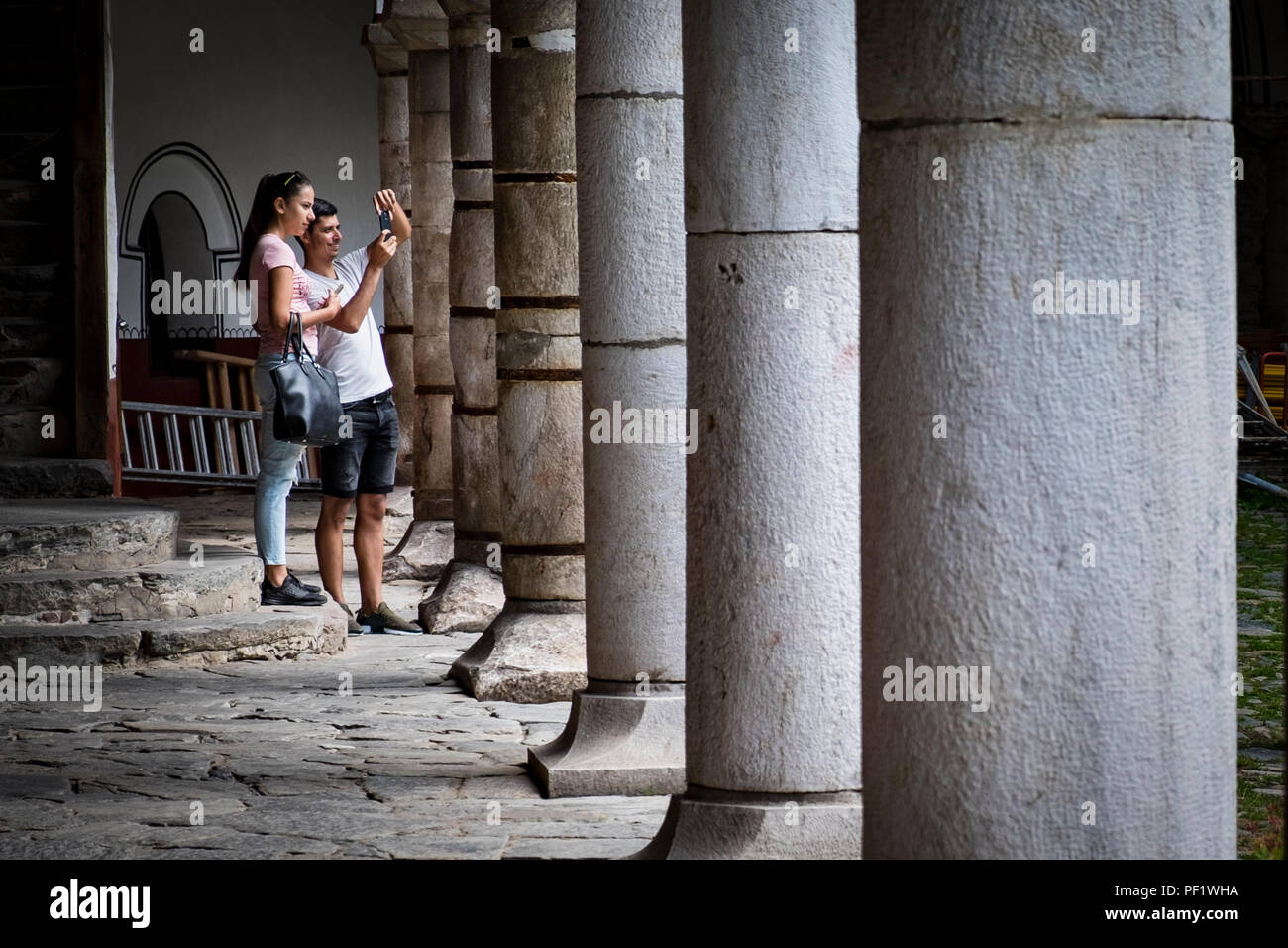 Un jeune couple en vacances Prenez une photo dans la cour du monastère de Rila en Bulgarie Banque D'Images