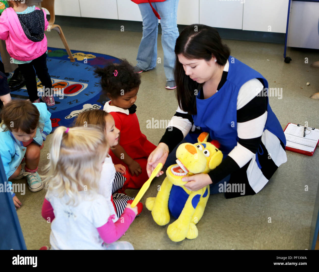 Danielle Tynan, assistant de programme au Centre de développement de l'enfant de San Onofre, enseigne aux enfants la bonne façon de se brosser les dents au cours d'un programme de sensibilisation de la santé dentaire effectué par 1er Bataillon dentaire, 1er Groupe logistique maritime à bord, Camp Pendleton, Californie, le 23 février 2016. Bn dentaire. a été aux écoles et centres de développement de l'enfant autour de Camp Pendleton durant le mois de février pour le mois de la santé dentaire des enfants d'enseigner de bonnes habitudes d'hygiène buccale et de promouvoir la santé dentaire. (U.S. Marine Corps photo par le Cpl. Carson Gramley/libérés) Banque D'Images