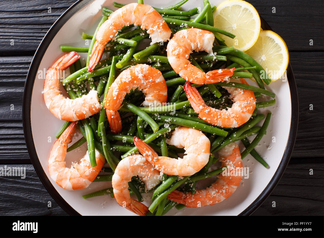 Faire revenir les crevettes avec des haricots verts, du fromage et de citron sur une assiette sur la table. haut horizontale Vue de dessus Banque D'Images