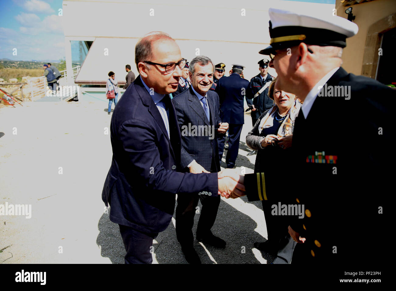 Corrado Bonfanti, maire de Noto, en Sicile, et le lieutenant de la Marine Derrick Horne, outillage spécial air-sol marin crise Response-Africa Task force de combat, aumônier de l'élément logistique saluent à la Villa Romana del Tellaro site archéologique, le 26 février, dans la région de Noto, Italie. Plus de 20 Marines et marins avec un SPMAGTF-CR-AF LCE offert leur temps couper l'herbe sur le site archéologique, une ancienne maison de campagne romaine pour la classe supérieure au cours de l'Empire romain, qui a marqué les relations communautaires 100e même les Marines et les marins avec le SPMAGTF-CR-AF ont participé pendant le déploiement. T Banque D'Images