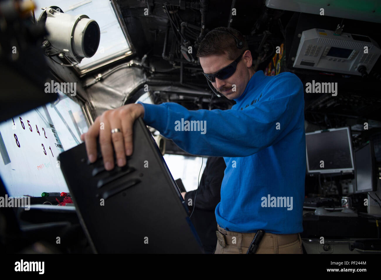 160227-N-YL073-071 GOLFE Arabo-persique (fév. 27, 2016) Le lieutenant Christopher Krueger, de Houston, utilise un protocole de communication de contrôle de la circulation aérienne (SATCC) dans la borne de commande de vol primaire à bord du navire d'assaut amphibie USS Kearsarge (DG 3). Kearsarge est le navire amiral de la groupe amphibie Kearsarge (ARG) et, avec la 26e unité expéditionnaire de Marines embarqués (MEU), est déployé à l'appui d'opérations de sécurité maritime et les efforts de coopération en matière de sécurité dans le théâtre dans la 5e flotte américaine zone d'opérations. (U.S. Photo par marine Spécialiste de la communication de masse 2e classe/Purifoy Mme Qureshi) Parution Banque D'Images