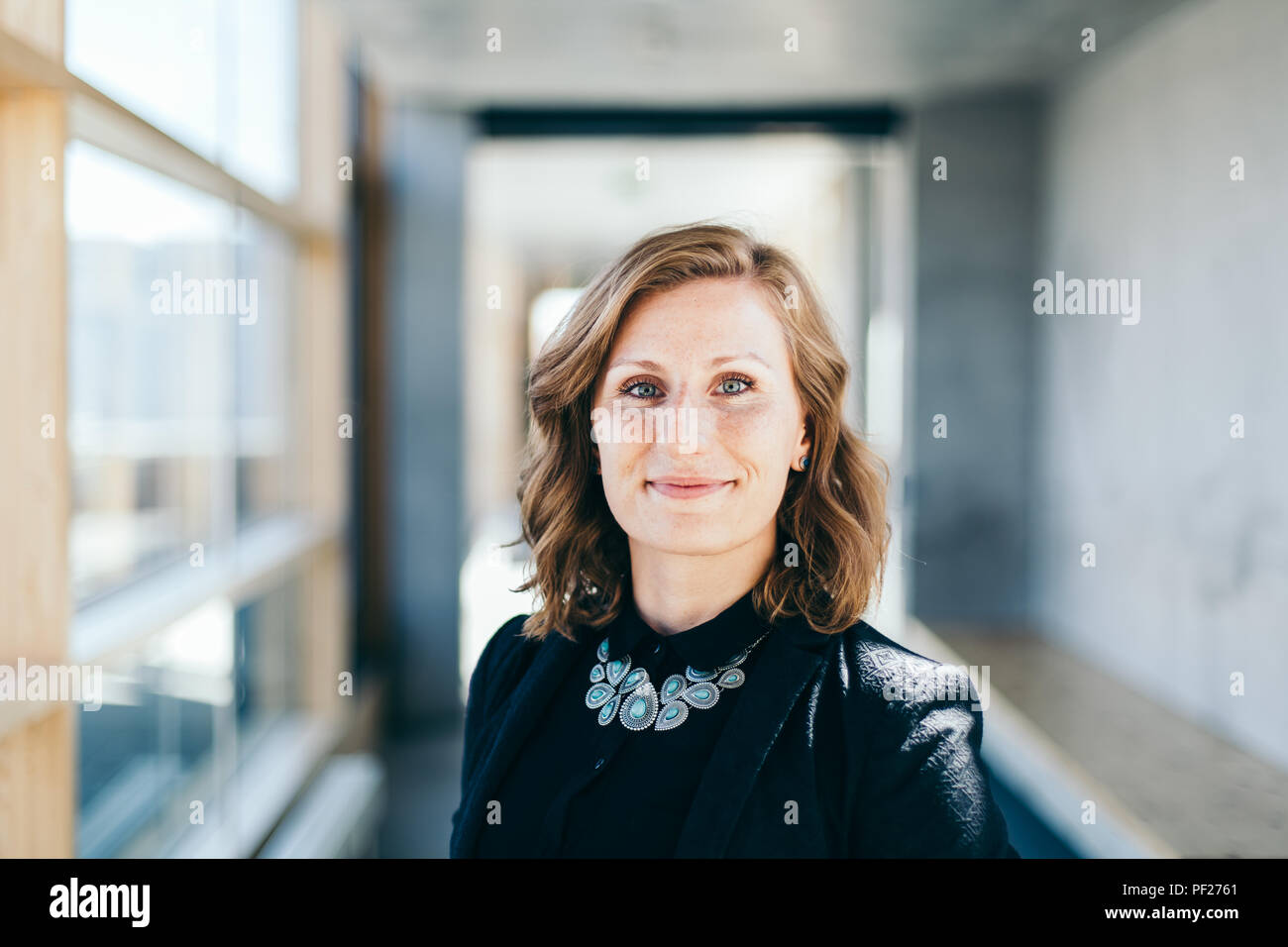 La confiance des entreprises et élégante femme sourit à l'appareil photo Banque D'Images