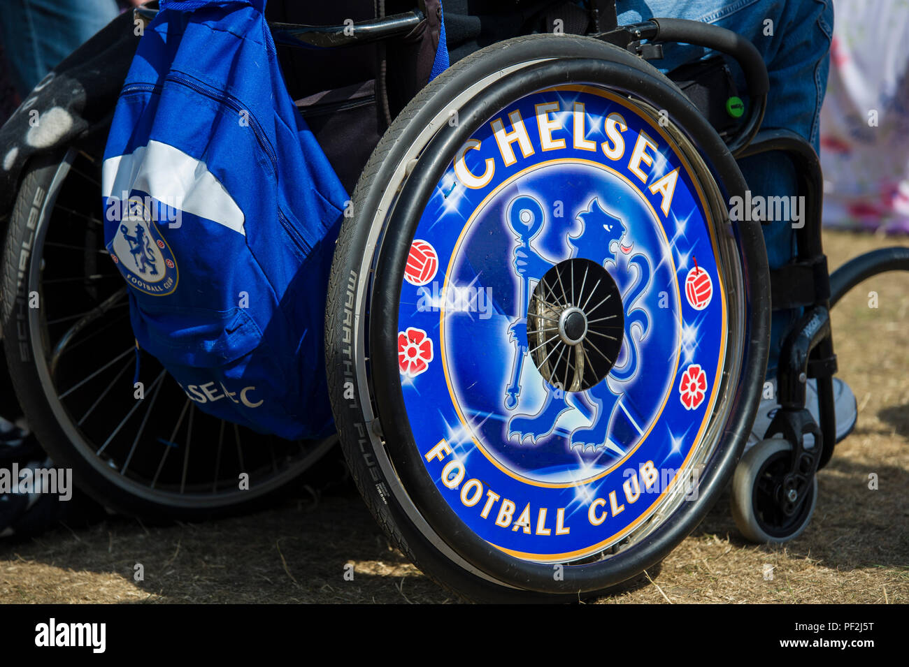 Un gros plan d'un supporter du Club de Football de Chelsea avec CFC, le fauteuil roulant les chapeaux de moyeu et ruck sack Banque D'Images