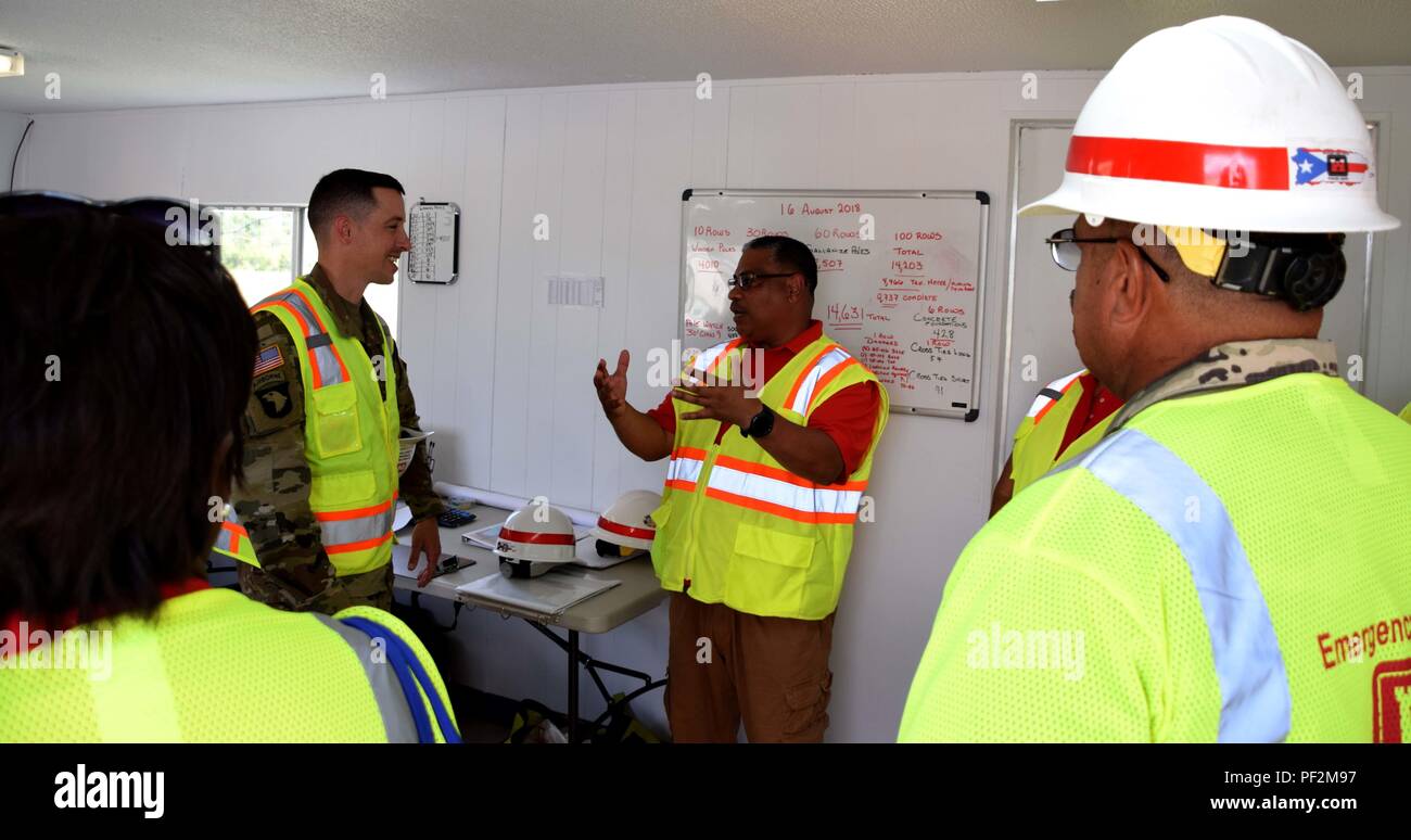 U.S. Army Corps of Engineers, Task-force Recouvrement LTC Commandant John Cunningham parle avec contrôle des matériaux Jose Diaz spécialiste au triage de posage à Aguadilla, Puerto Rico, où une partie des matériaux pour la restauration du réseau électrique sont stockés, le 17 août 2018. Dans le cadre de la Mission du Corps des ingénieurs, la FEMA réalisé à l'USACE ont une responsabilité centrale pour l'achat et la distribution de tous les projet de loi de matériel (BOM) pour la mission de restauration de la grille. Banque D'Images