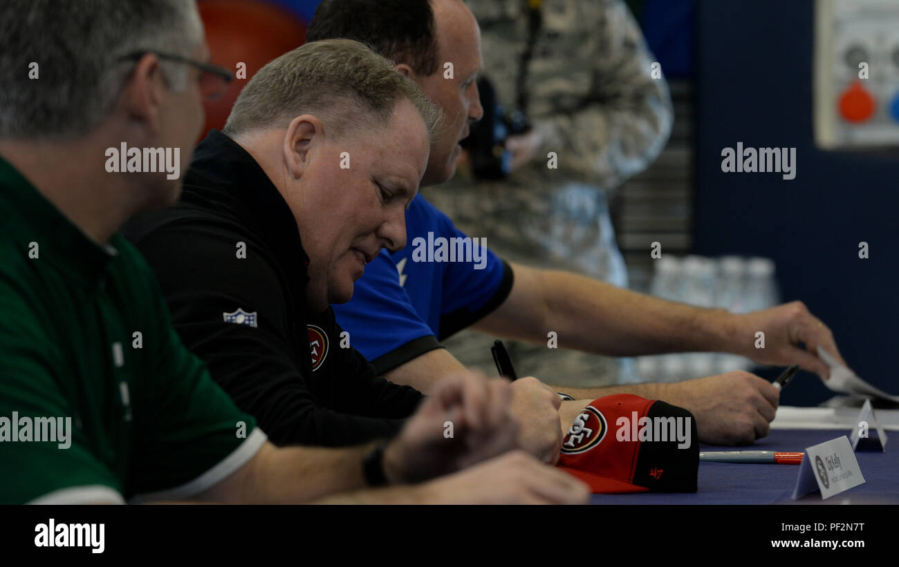 Chip Kelly, San Francisco 49ers entraîneur-chef, signe un cap sports au cours de la tournée 2016 Les entraîneurs, le 18 février 2016, à la base aérienne d'Aviano, en Italie. Les entraîneurs de l'équipe a rencontré des membres de l'Aviano pour répondre aux questions et accueillir une maquette moissonneuse-batteuse de football. (U.S. Air Force photo par un membre de la 1re classe Cary Smith/libérés) Banque D'Images