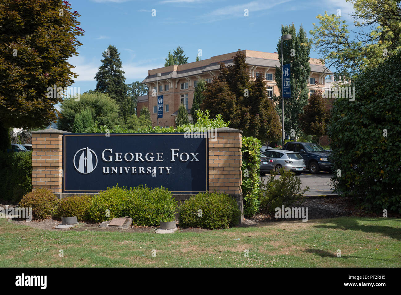 NEWBERG, Oregon le 15 août 2017, un panneau à l'entrée de George Fox University, avec un bâtiment en brique à l'arrière-plan. Banque D'Images