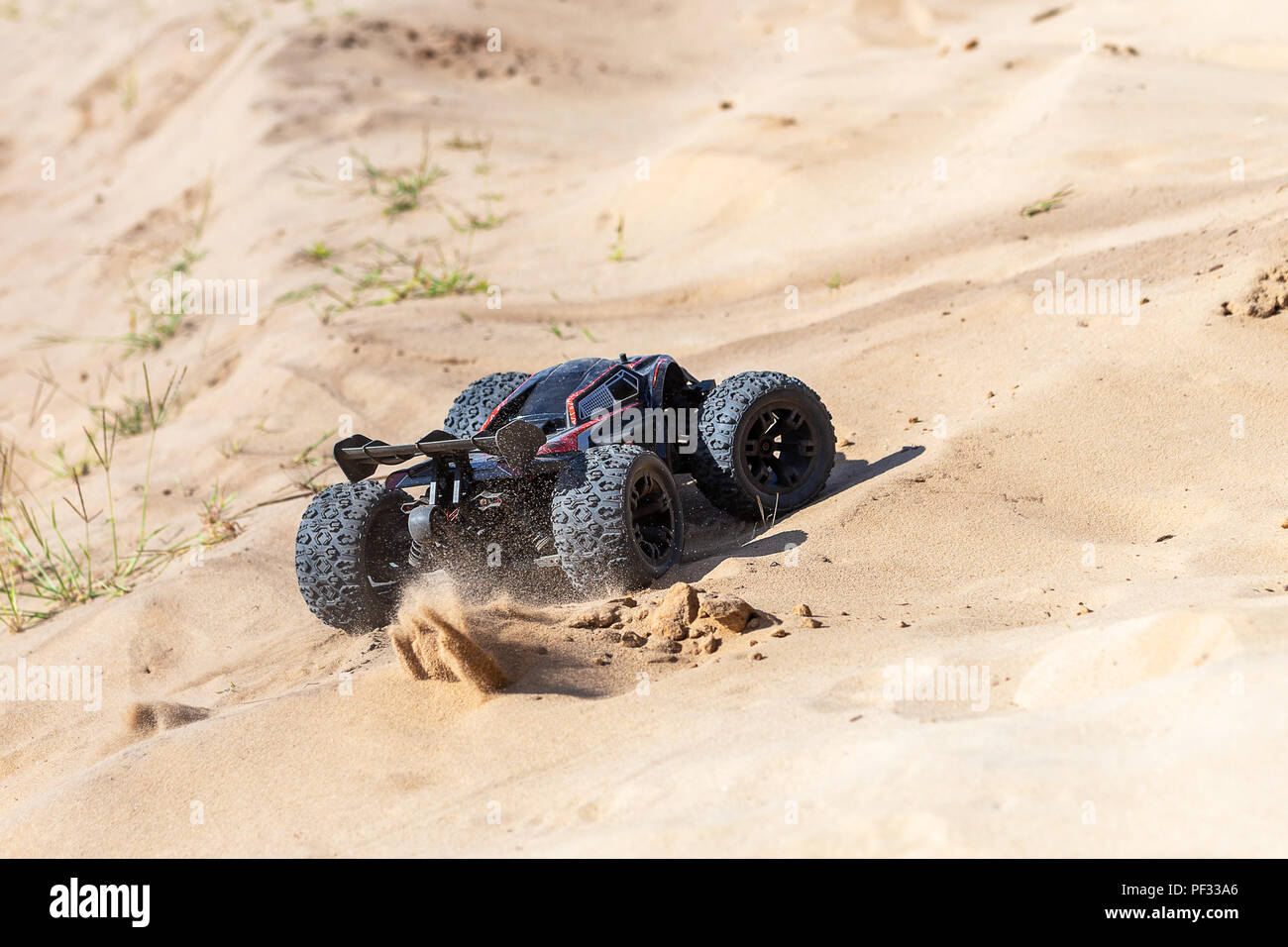 Grosse voiture buggy radio-commandé conduite rapide et glisser sur le sable. RC toy se déplaçant rapidement sur la surface du terrain avec la poussière et la boue à l'extérieur. Enfants hobby concept Banque D'Images
