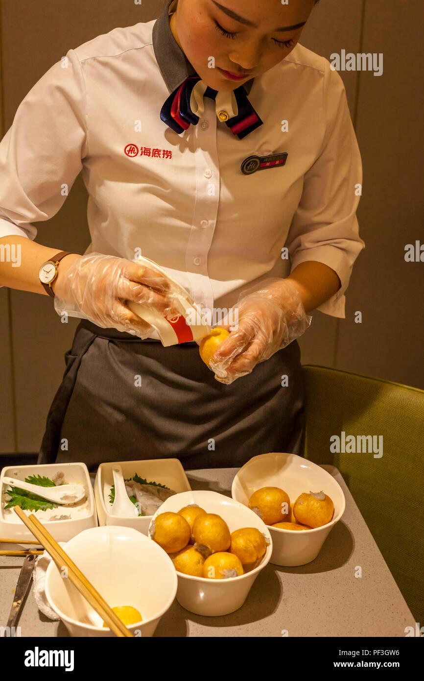 Nanjing, Jiangsu, Chine. Serveuse en boules de gluten Oeufs farcis au boeuf, oignons verts,. Restaurant Haidilao. Banque D'Images Nanjing, Jiangsu, Chine. Serveuse en boules de gluten Oeufs farcis au boeuf, oignons verts,. Restaurant Haidilao. Banque D'Images