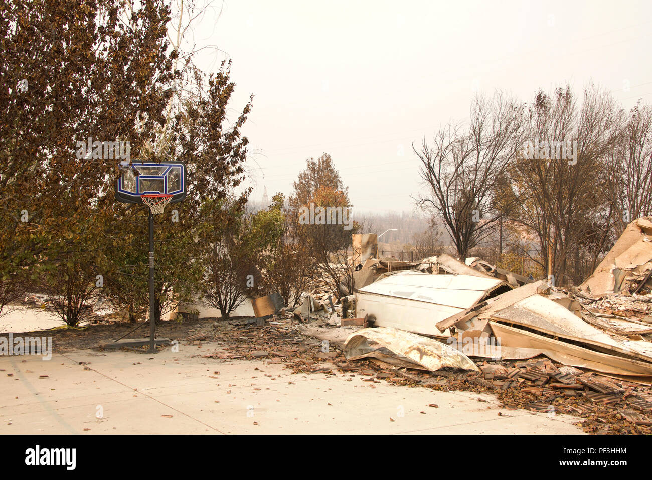 Accueil brûlé à la terre, porte de garage bouclée mais intacte après le basket-ball le feu sauvage tempête de feu dans la région de Redding, CA. La fumée et des cendres dans l'air une Banque D'Images