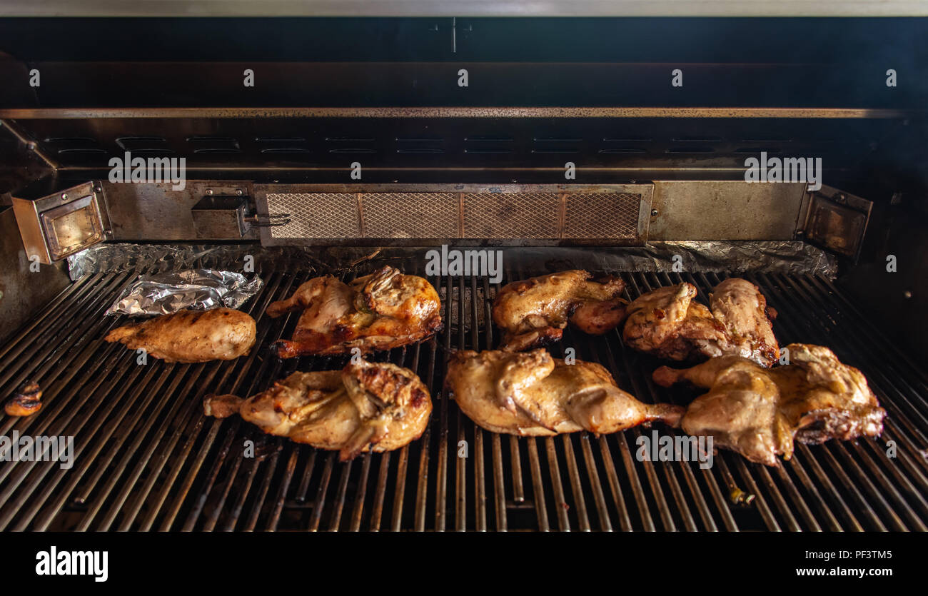 Poulets griller sur un gril à gaz Banque D'Images