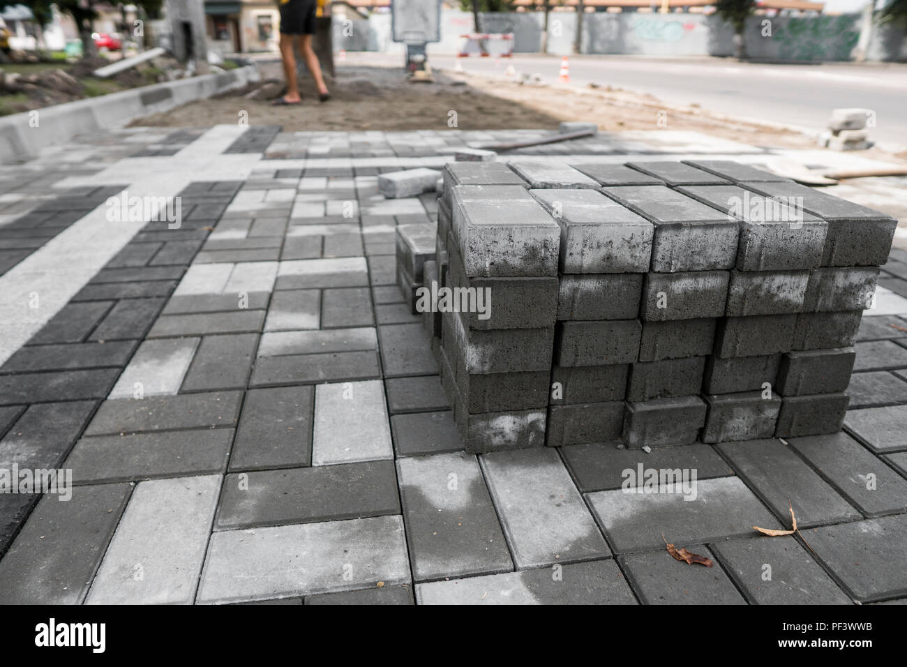 Pavés de la chaussée dans la pile dans la rue. Ou en béton gris granit dalles pavés carrés pour la construction d'un trottoir. La fabrication de l'industrie ou la construction de concept. Les matériaux de construction Banque D'Images
