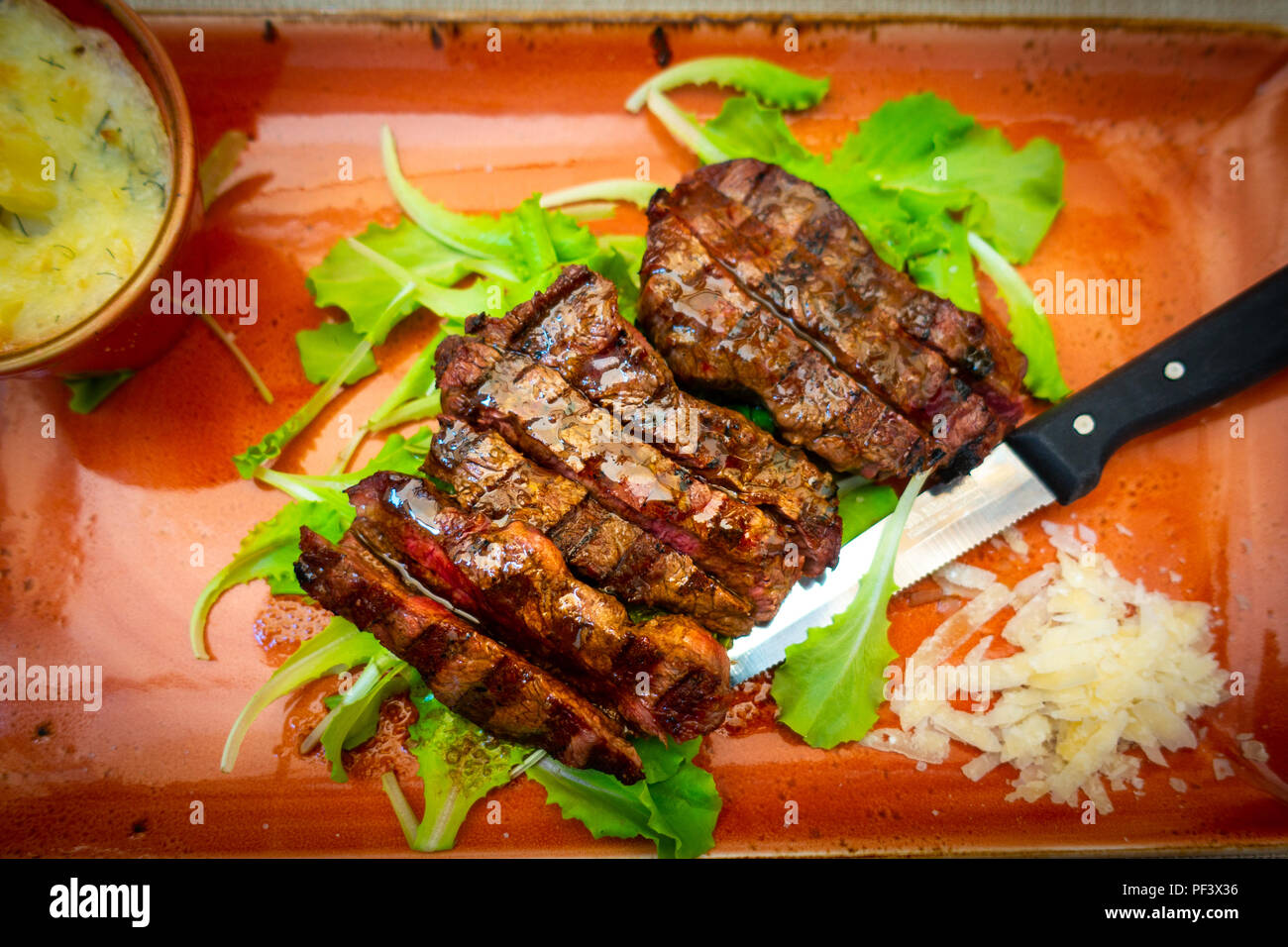 Italien traditionnel steak tagliata de parmesan et salade comme close-up sur une plaque Banque D'Images