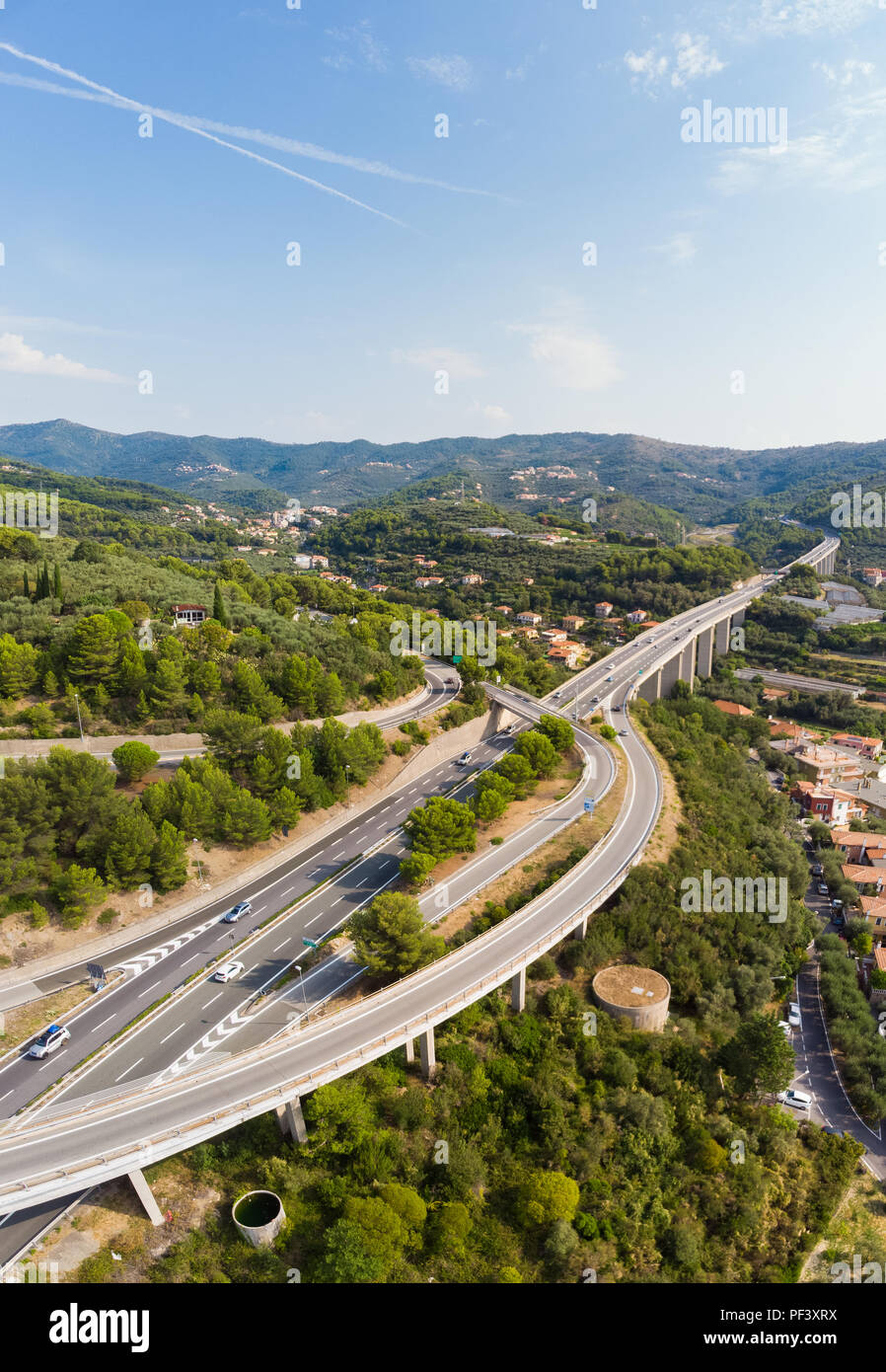 Vue aérienne de plusieurs voies traversant les villages et les collines de la forêt (Autostrada dei Fiori - A10) Ligurie Italie Banque D'Images