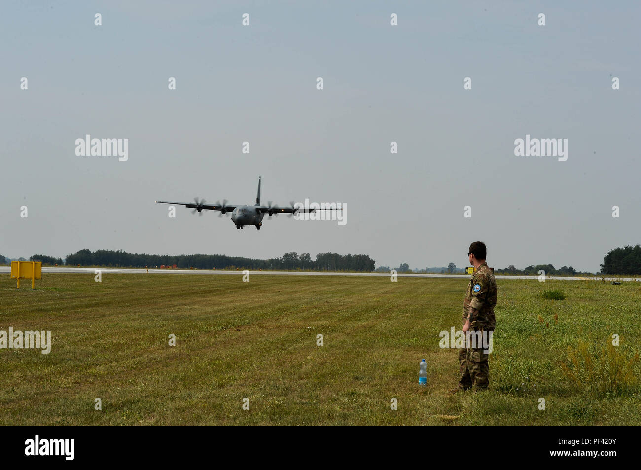 U.S. Air Force Tech. Le Sgt. Joshua Todd, 435ème Groupe d'intervention d'urgence spécialiste météo, montres un Polish Air Force C-130E la terre sur la base aérienne de Powidz, Pologne, 9 août, 2018. Les aviateurs américains à partir de la Base aérienne de Ramstein, en Allemagne, est arrivé en Pologne pour effectuer des exercices bilatéraux avec l'Armée de l'Air polonaise. (U.S. Photo de l'Armée de l'air par la Haute Airman Joshua Magbanua) Banque D'Images