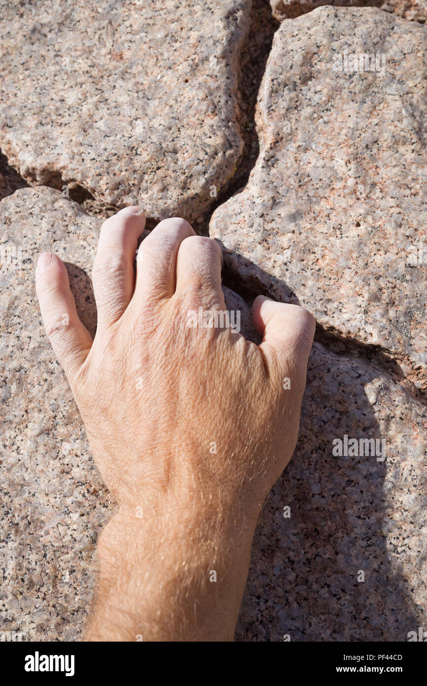 Male rock climber main empoigner un crack rock Banque D'Images