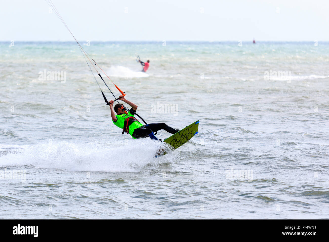 Kitesurf freestyle National Championships à Ramsgate. Close-up, l'homme kitesurf, surf le long de mer tout en maintenant la commande bar et lignes de vol (invisible) cerf-volant. Banque D'Images