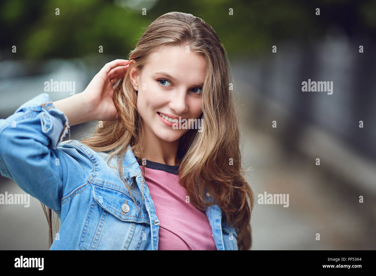 Une blonde happy girl smiles dans un style urbain. Banque D'Images