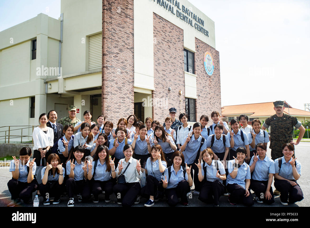 Les étudiants de l'École d'hygiène dentaire Okinawa stand avec les dentistes de la Marine américaine et le personnel de la clinique dentaire de la Direction générale de la Marine américaine, Evans Centre dentaire, sur Camp Foster, Okinawa, Japon, le 10 août 2018. Les élèves ont visité les installations et s'est entretenu avec des experts dentaires avec 3e Bataillon dentaire, 3e Groupe logistique maritime pour mieux comprendre le domaine dentaire et les opérations quotidiennes. Les étudiants sont en ce moment sur leur deuxième année d'un cours de trois ans. (U.S. Marine Corps photo par le Cpl. Joshua Pinkney) Banque D'Images