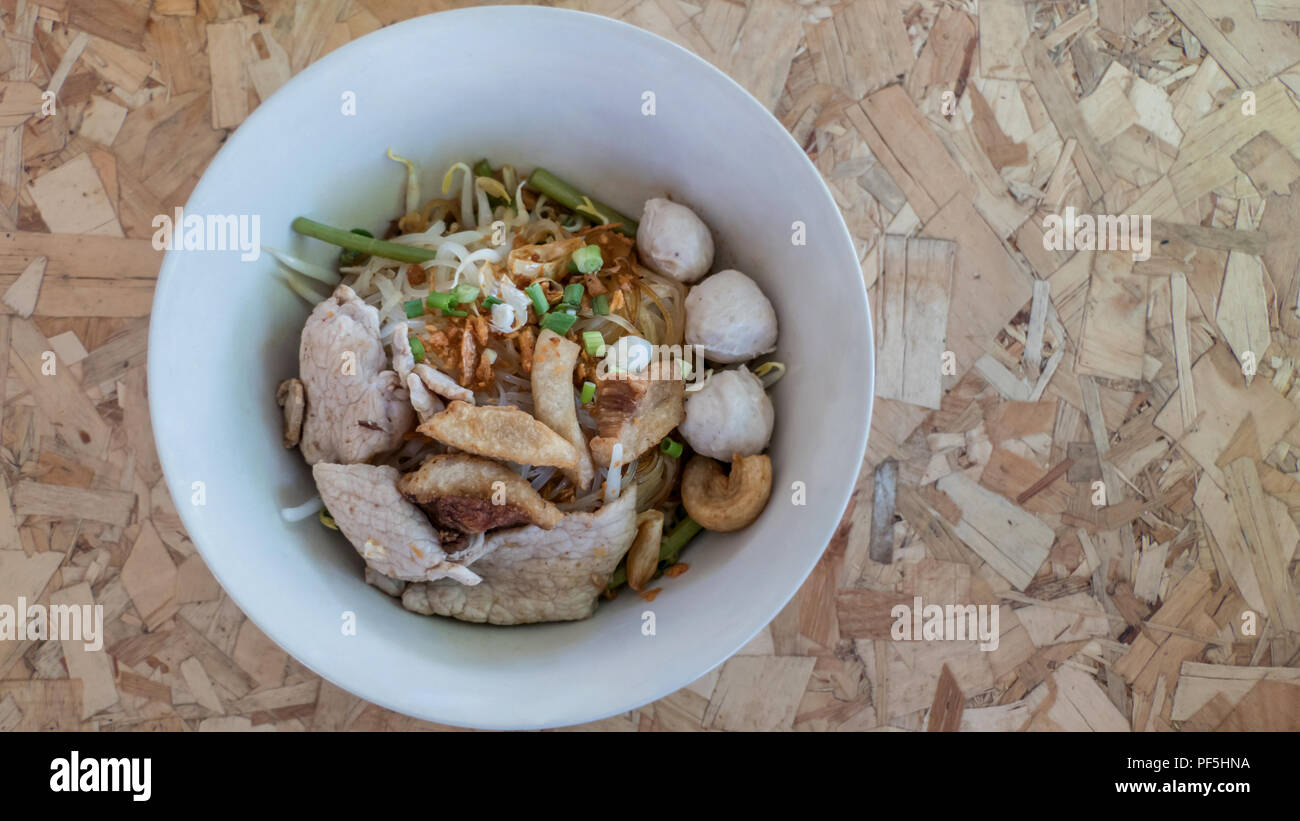 Vue de dessus de la soupe de nouilles asiatiques avec légumes et boulettes de bœuf sur fond de bois Banque D'Images