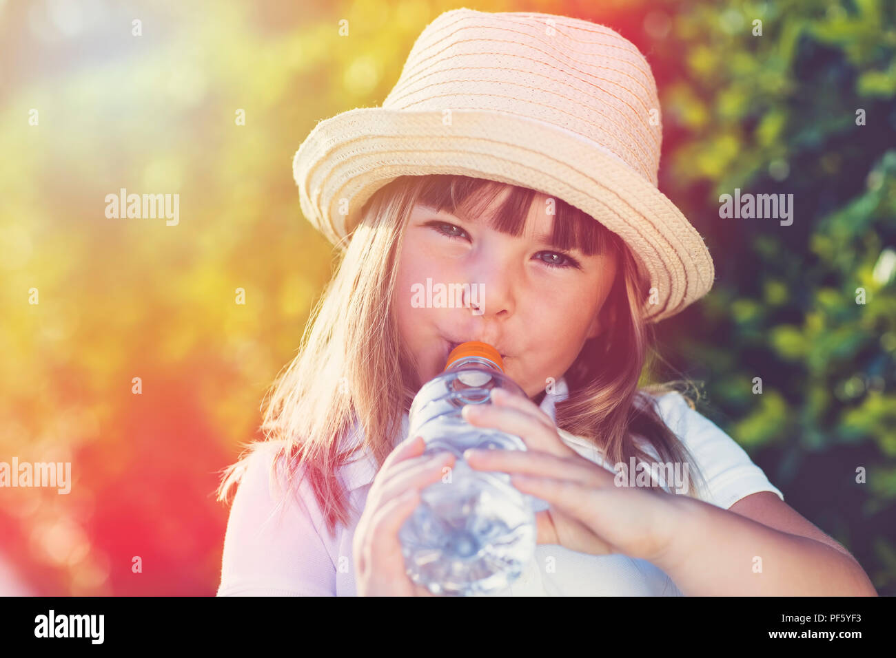 Cute little girl l'eau potable en été Banque D'Images