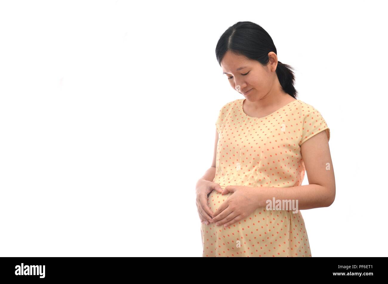 Pregnant Asian woman avec mignon bébé à l'intérieur et tenir la main chaude montrant l'amour de la mère et les soins avec fond blanc Banque D'Images