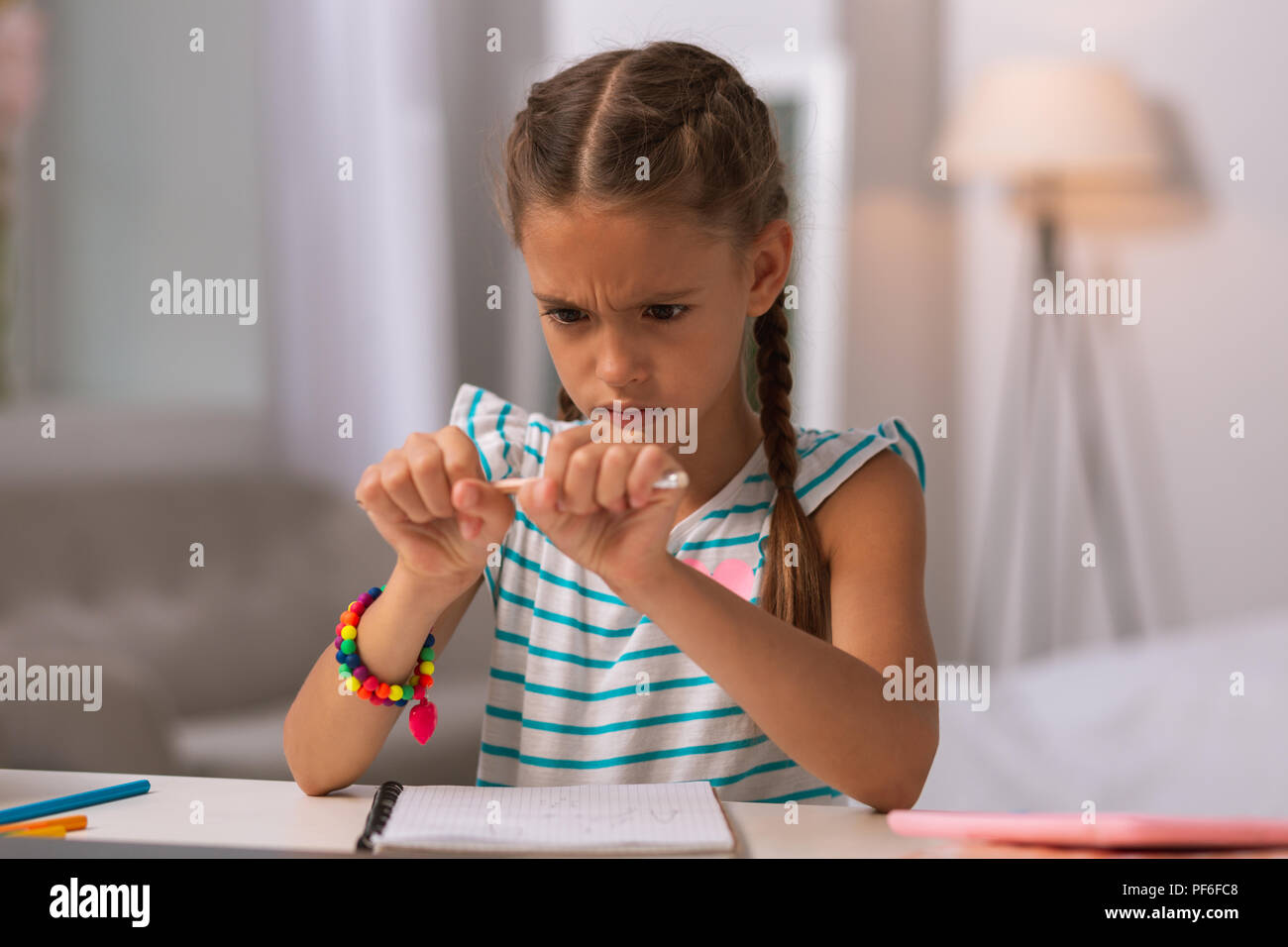 En colère dépression girl holding un crayon à la maison Banque D'Images
