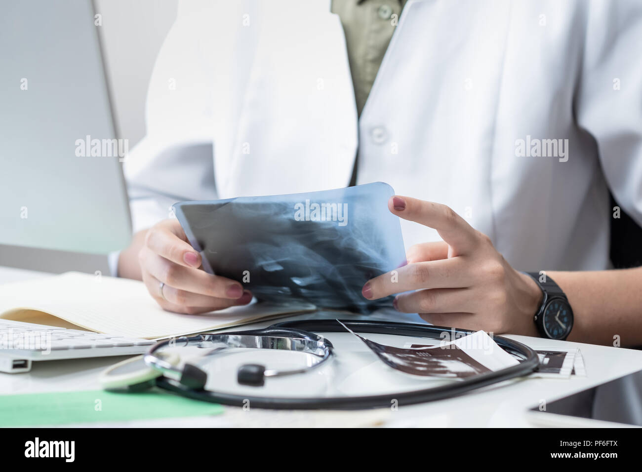 Femme médecin à médecin moderne bureau. Woman examining x-ray sur le lieu de travail devant un ordinateur de bureau Banque D'Images