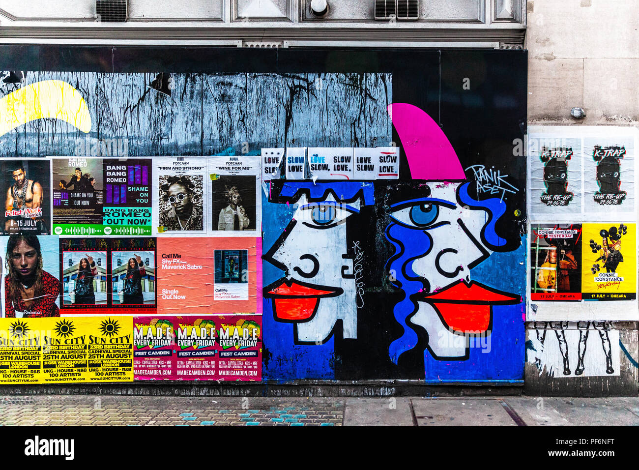 Mur extérieur recouvert d'affiches publicitaires colorées et de graffiti, Noel Street, Soho, Londres, W1F, Angleterre, Royaume-Uni. Banque D'Images