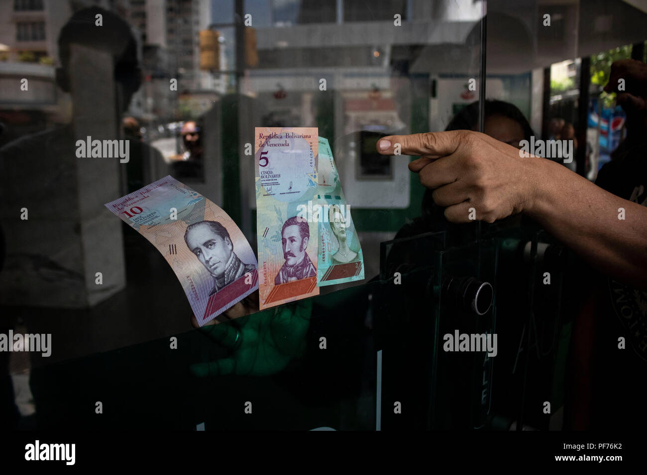 Caracas, Venezuela. 20e Août, 2018. Nouveaux billets s'en tenir à la porte d'entrée d'une banque. Avec toute une série de réformes, le gouvernement vénézuélien veut résoudre la grave crise économique dans le pays. Face à l'hyperinflation, cinq zéros ont été supprimés de la monnaie nationale. Un million de Bolívar fuerte (strong Bolívar) est devenu 10 Bolívar soberano souverain (Bolívar). En outre, le Bolívar est d'être liés à la nouvelle devise crypto Petro. Credit : Rayner Pena/dpa/Alamy Live News Banque D'Images