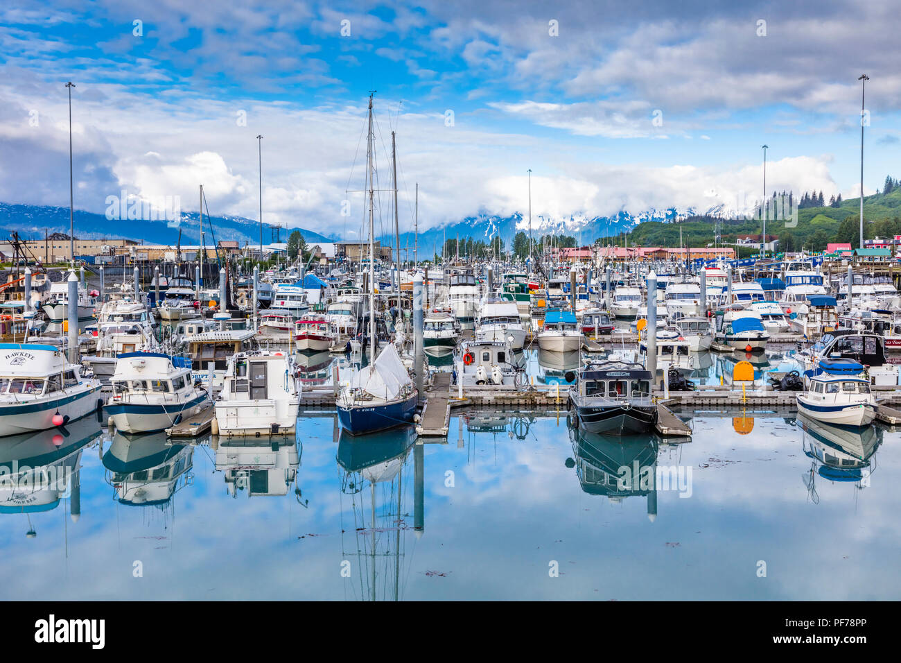 Gros nuages blancs avec des taches de ciel bleu sur petit bateau sur le port du Prince William en Alaska Valdez Banque D'Images