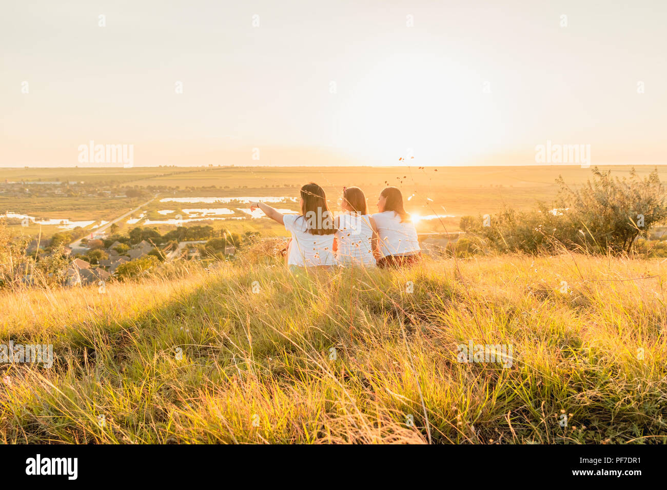 ETULIA, MOLDOVA - août 03, 2018 : Groupe de trois filles pour le coucher du soleil sur une colline à la campagne, de saut et de smiling Banque D'Images