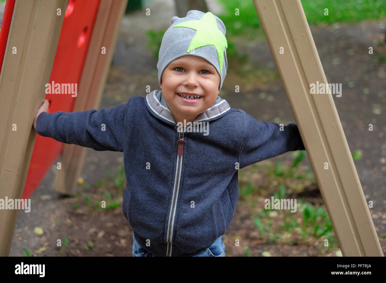 Petit Garçon jouant sur l'aire de jeux de plein air dans le parc en automne Banque D'Images